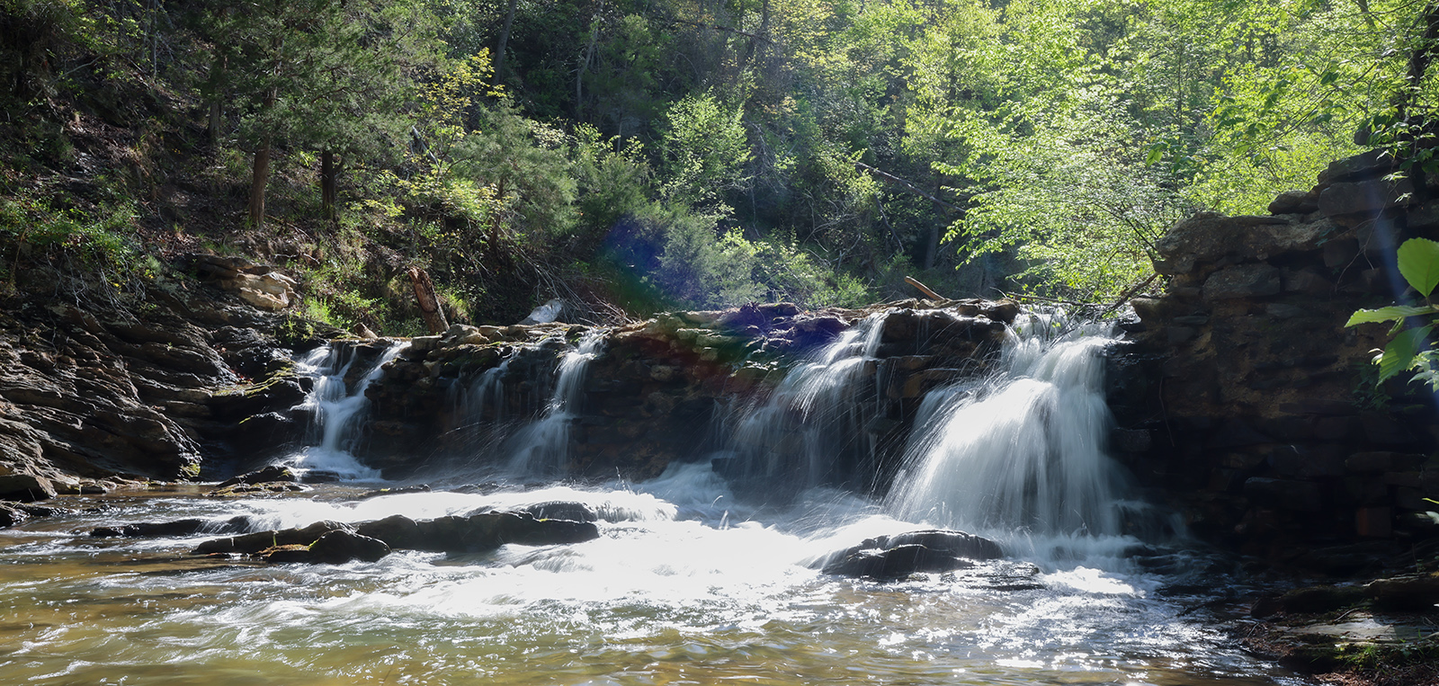 Una foto del agua fluyendo sobre una antigua presa.