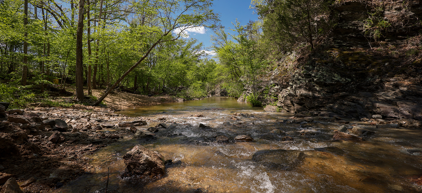 Una foto de un río que fluye libremente sobre unas rocas.