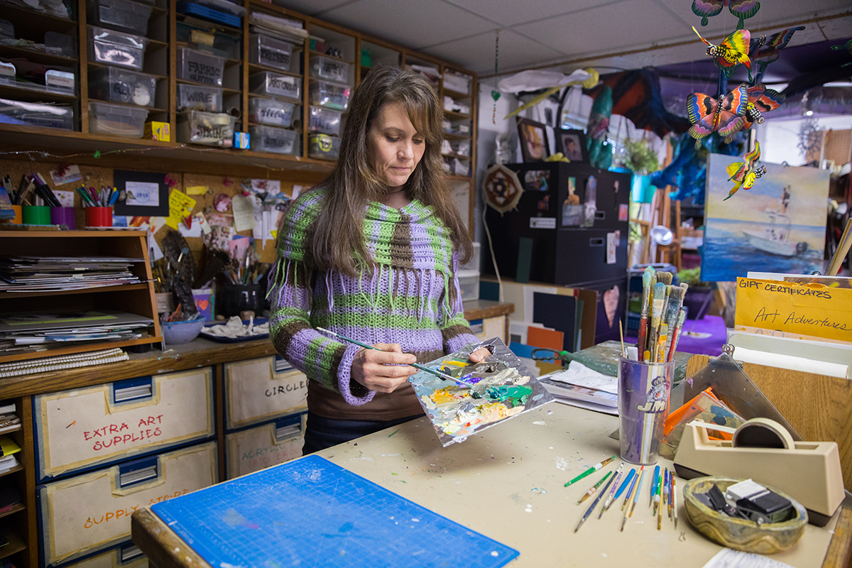 Imagen de una mujer en un estudio de arte preparando una paleta de pintura