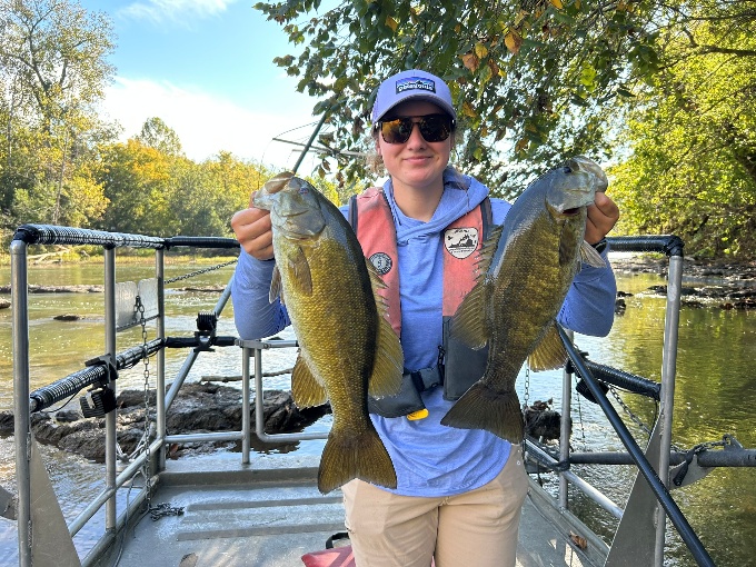 Un pescador en una barca con dos lubinas en el río South Fork Shenandoah.