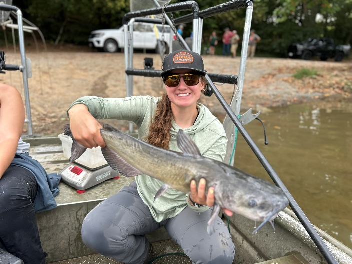 Un pescador en una barca sosteniendo un bagre de canal en el río South Fork Shenandoah.