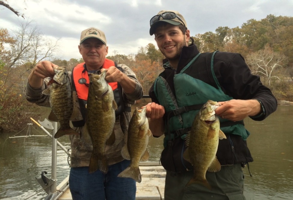 Dos pescadores en una barca con lubinas de boca pequeña en el río Staunton.