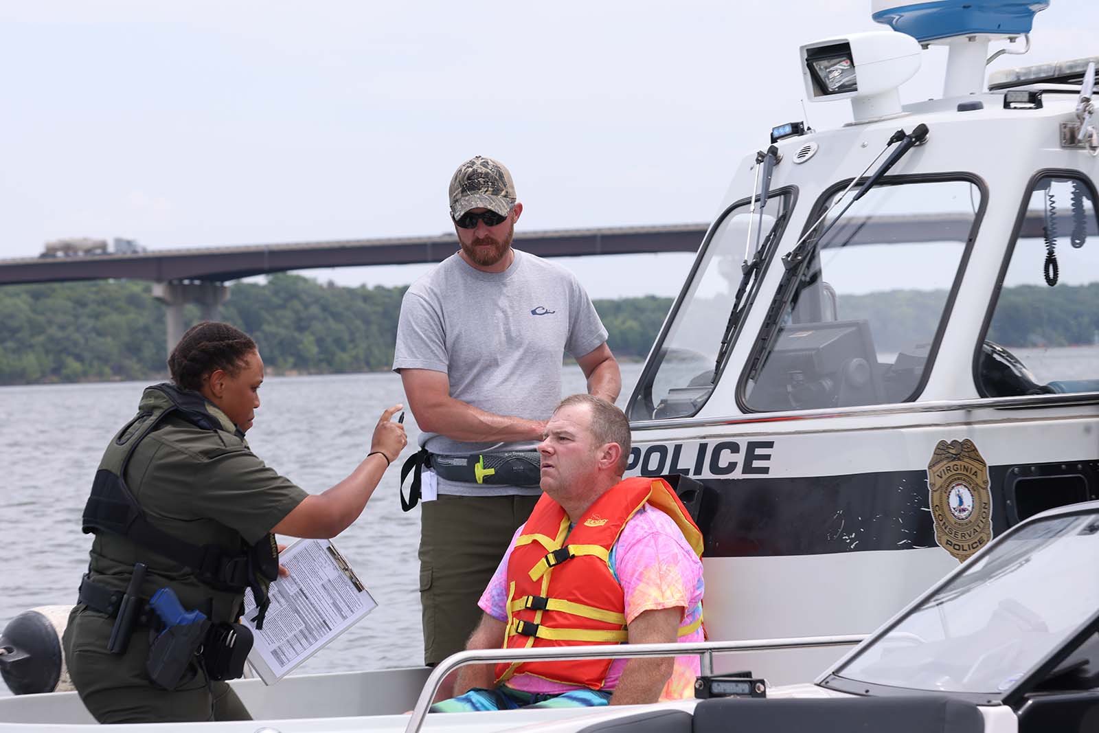 Un oficial de policía de conservación realiza una prueba de sobriedad de campo a un navegante