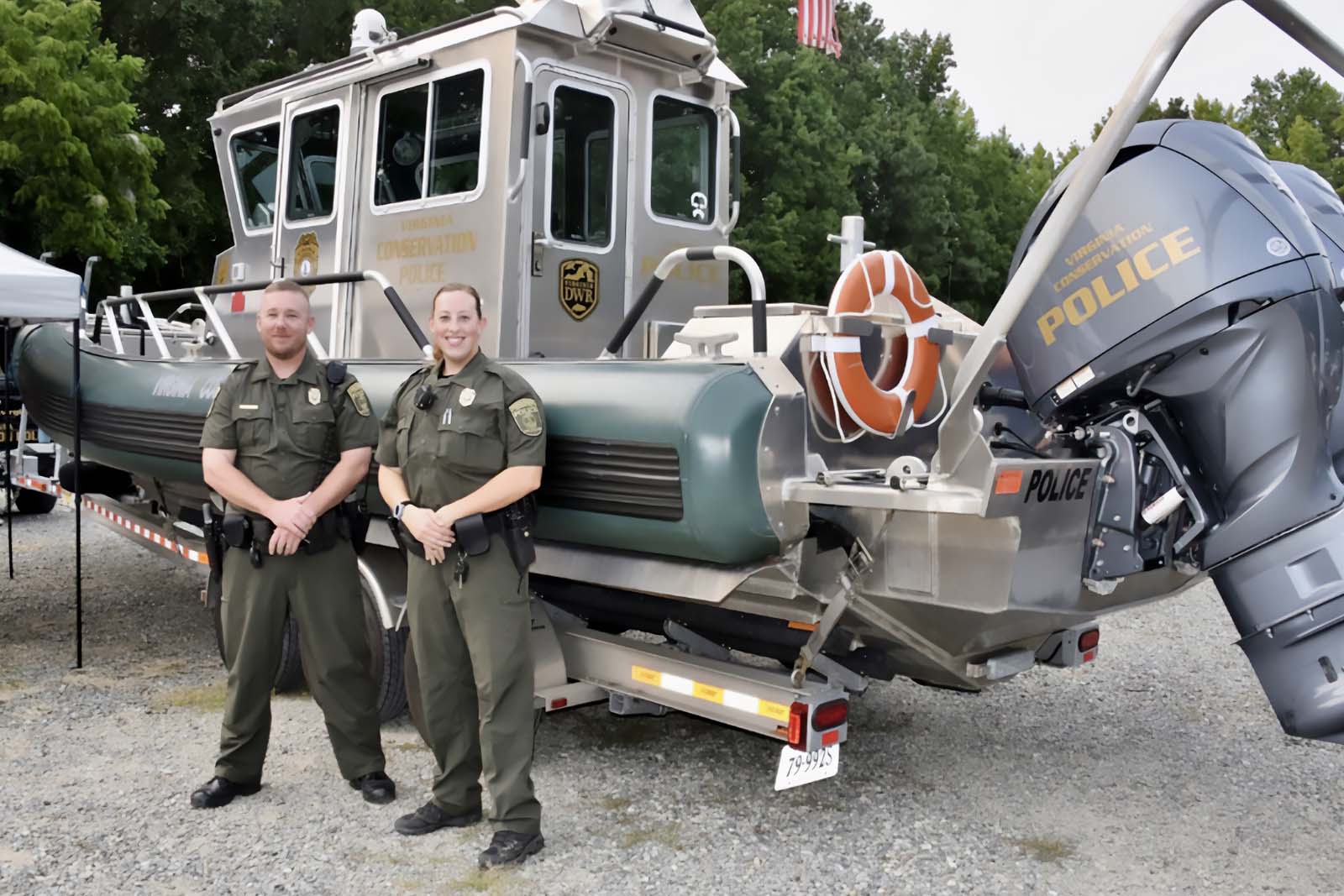 Los CPO se paran frente a un bote de la policía en un remolque