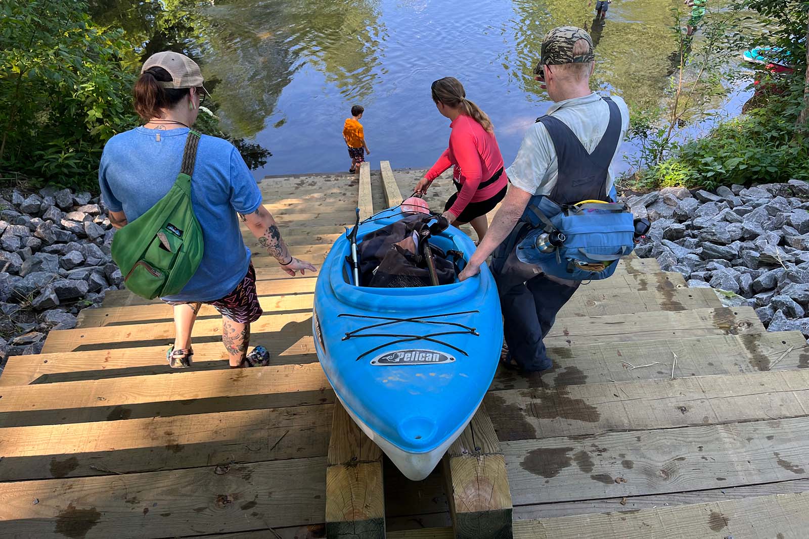 Personas cargando un kayak por una rampa para botes