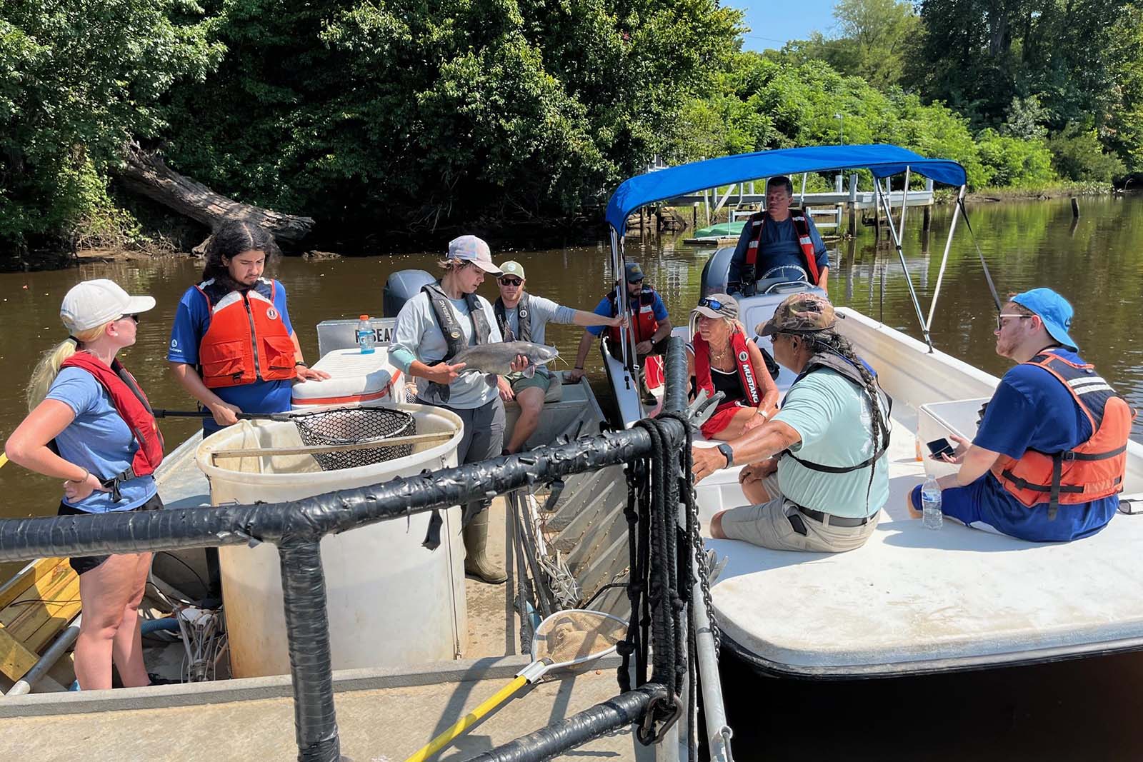 Personas trabajando en un río junto a un barco