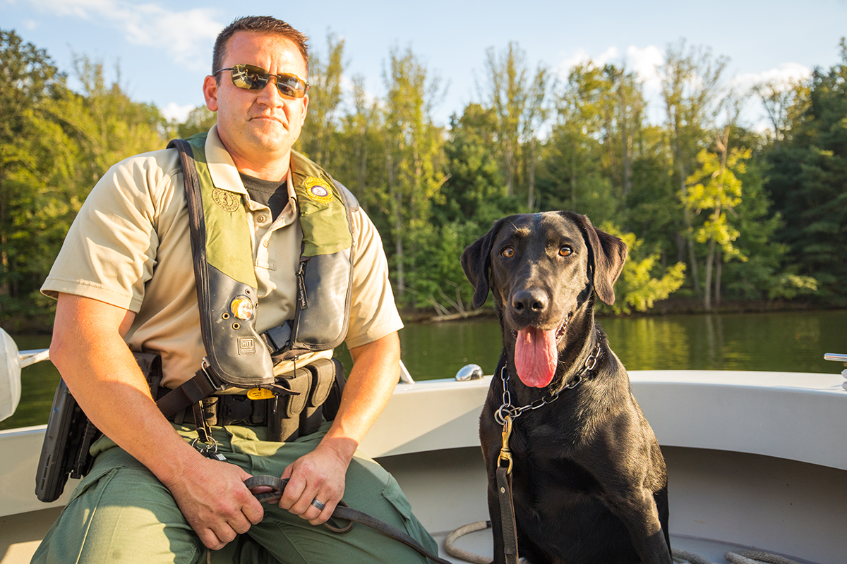 CPO Jim Patrillo y K9 Bailey, el labrador negro en un barco