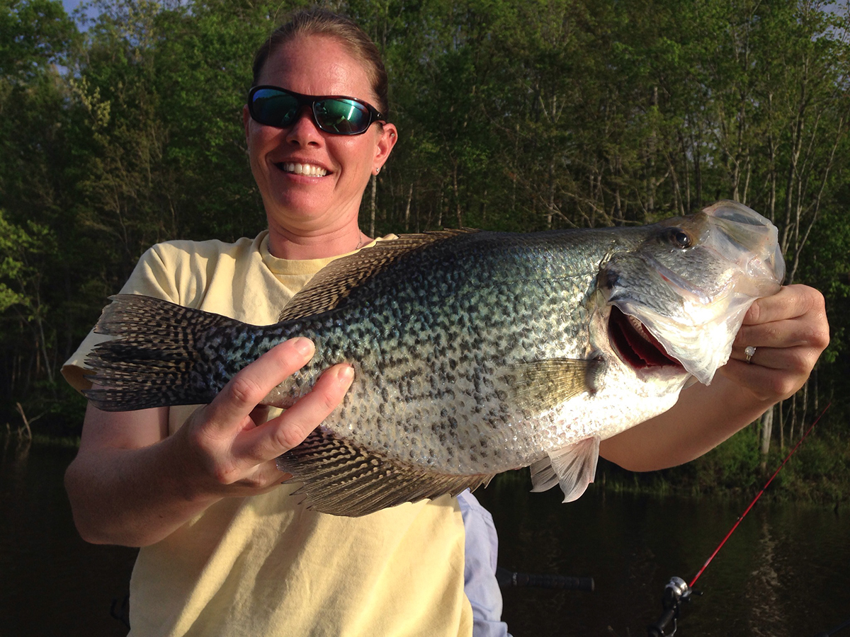 La sargento Jessica Whirley sosteniendo un pez que ha capturado