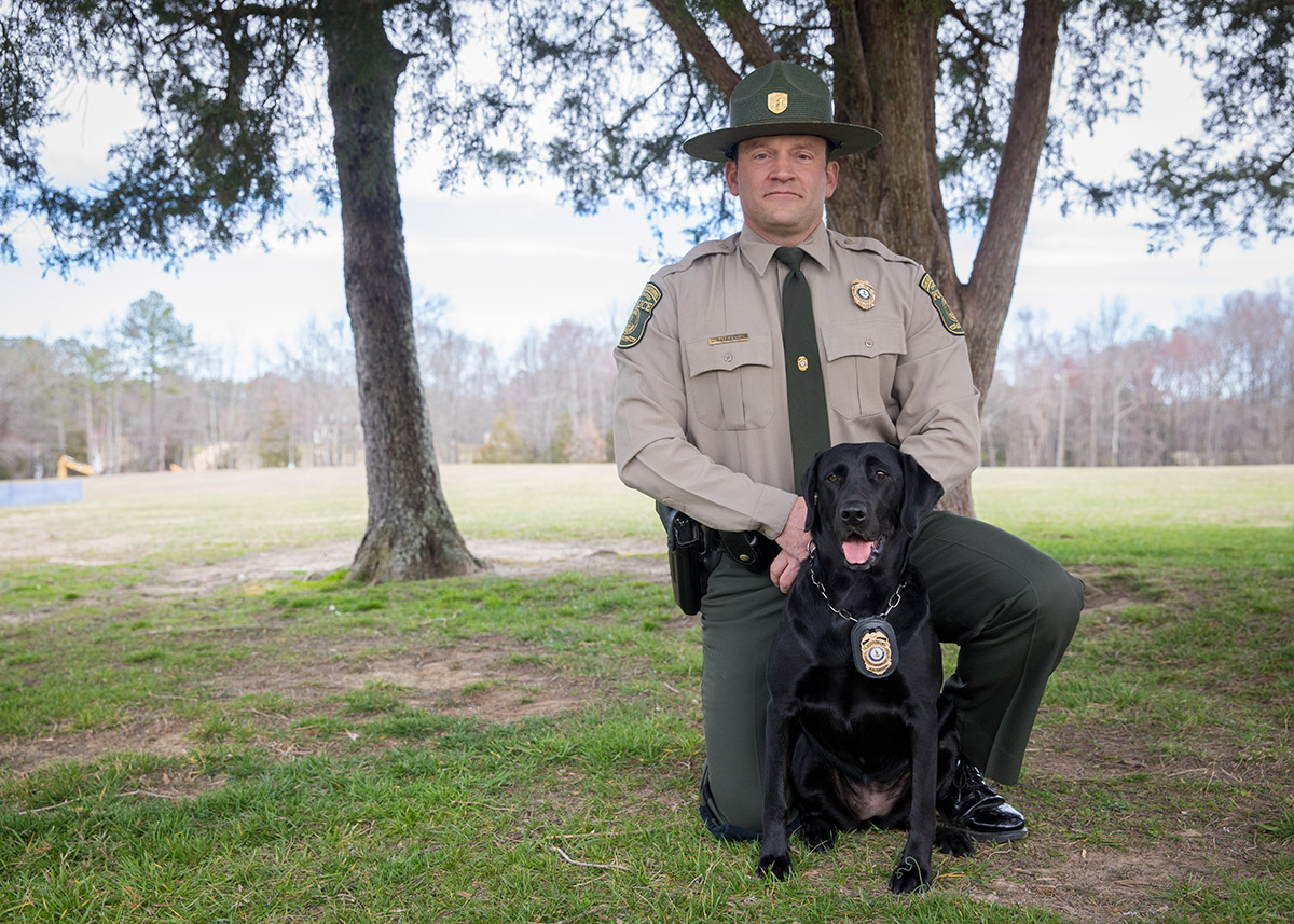 CPO Jim Patrillo y K9 Bailey, el labrador negro, posando para una foto