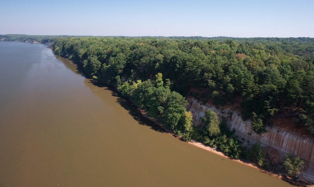 Una vista aérea de los acantilados de Fones; En esta imagen se puede ver el acantilado de color naranja escarpado debajo del dosel del bosque