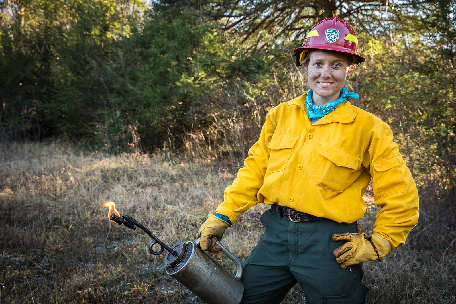 Un miembro del equipo de bomberos posa con una antorcha de goteo.
