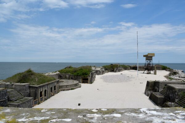 Una imagen de una pequeña ciudad de hormigón y metal en la playa