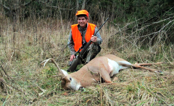 Imagen de un cazador posando con un ciervo muerto