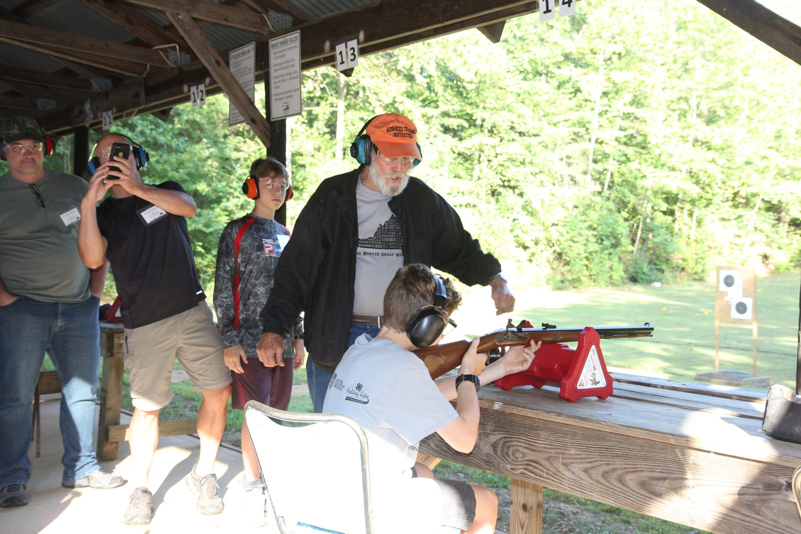 Una imagen de un niño aprendiendo a disparar un arma