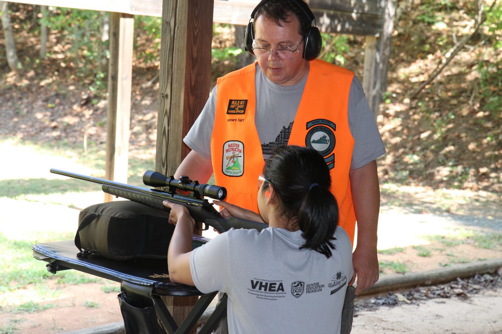 Una imagen de una niña aprendiendo a disparar un arma