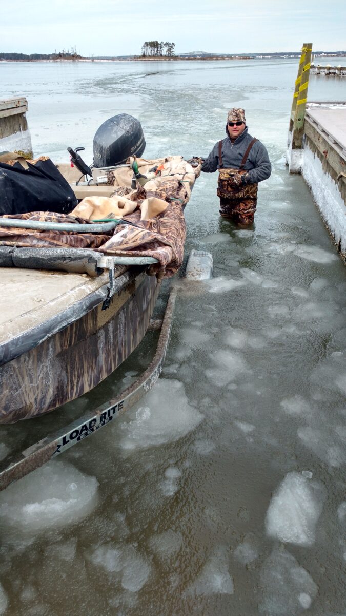 Imagen de un hombre en agua helada ayudando a atracar un barco