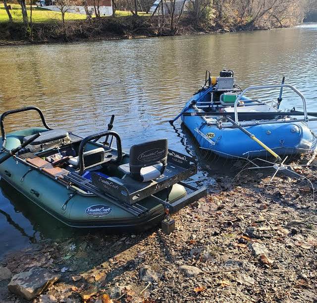 Una imagen de dos balsas diseñadas para la pesca eléctrica en la orilla de un cuerpo de agua local.