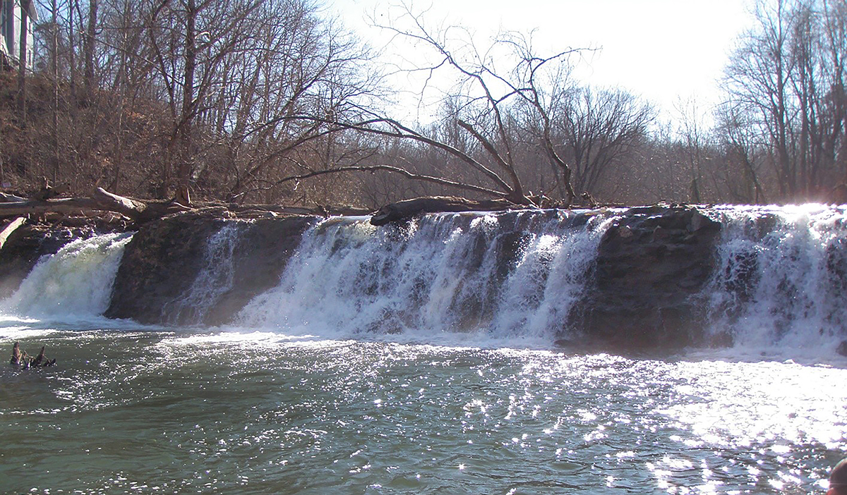 Una imagen de una gran presa de piedra con árboles caídos antes de ser removida
