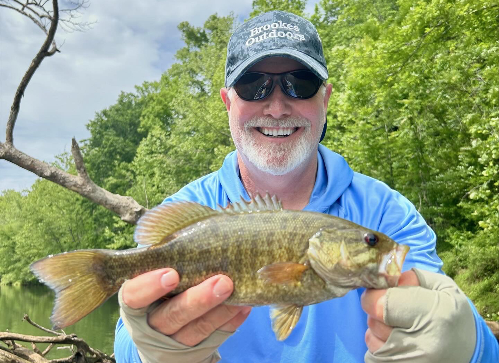 Un hombre sosteniendo una lubina de boca pequeña para una foto.