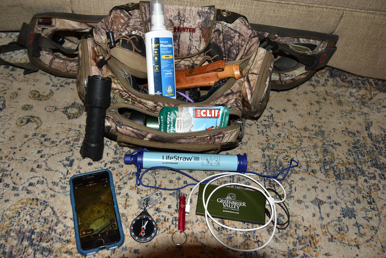 Una foto de un paquete con zíper con una variedad de artículos mostrados.