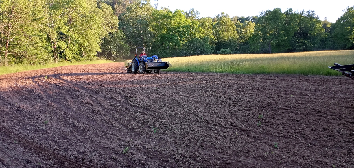 Una imagen de un tractor sembrando semillas para el corredor de vida silvestre 