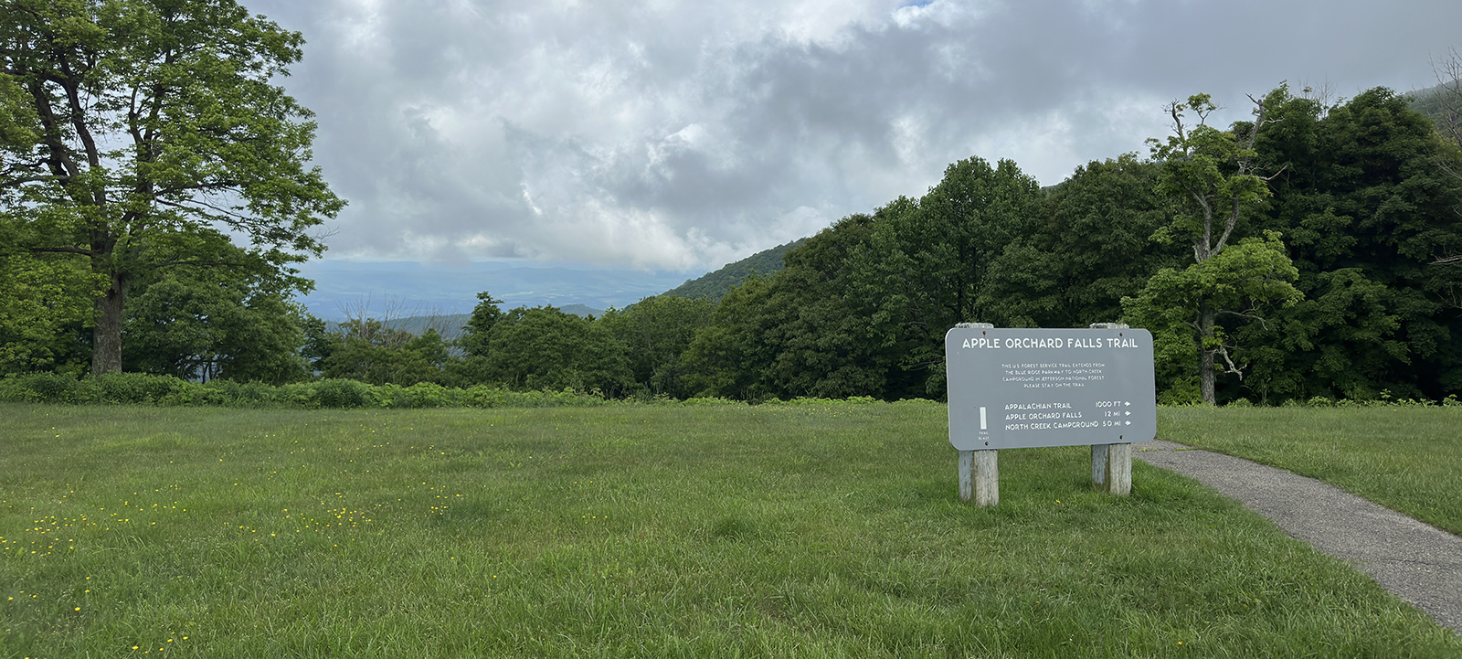 Una foto de un campo verde con vistas y un afiche interpretativo.