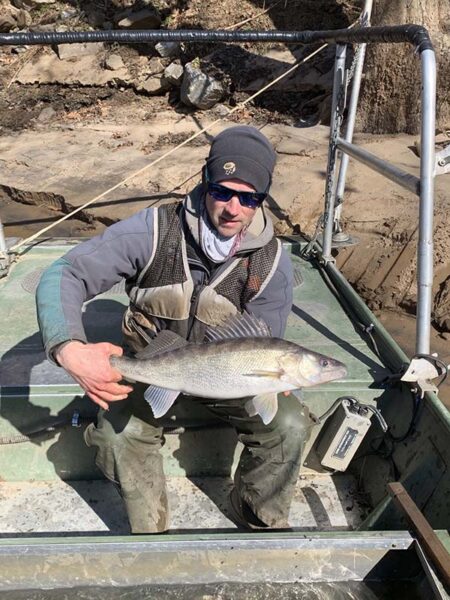 Un biólogo pesquero DWR sostiene un pez