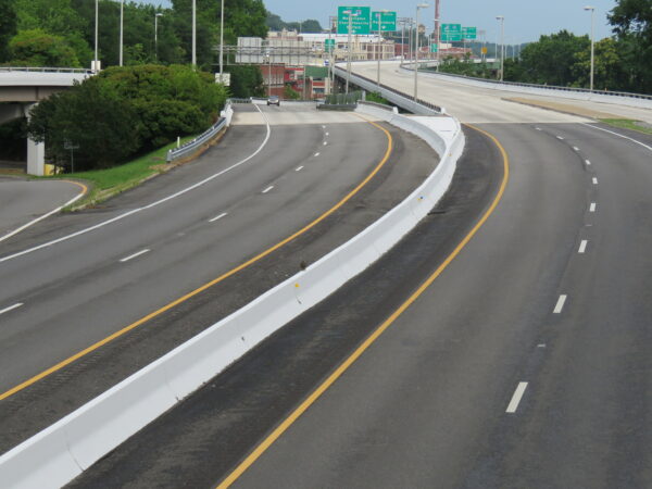 Polluelo de halcón en lo alto de una barrera de Jersey en la I-195
